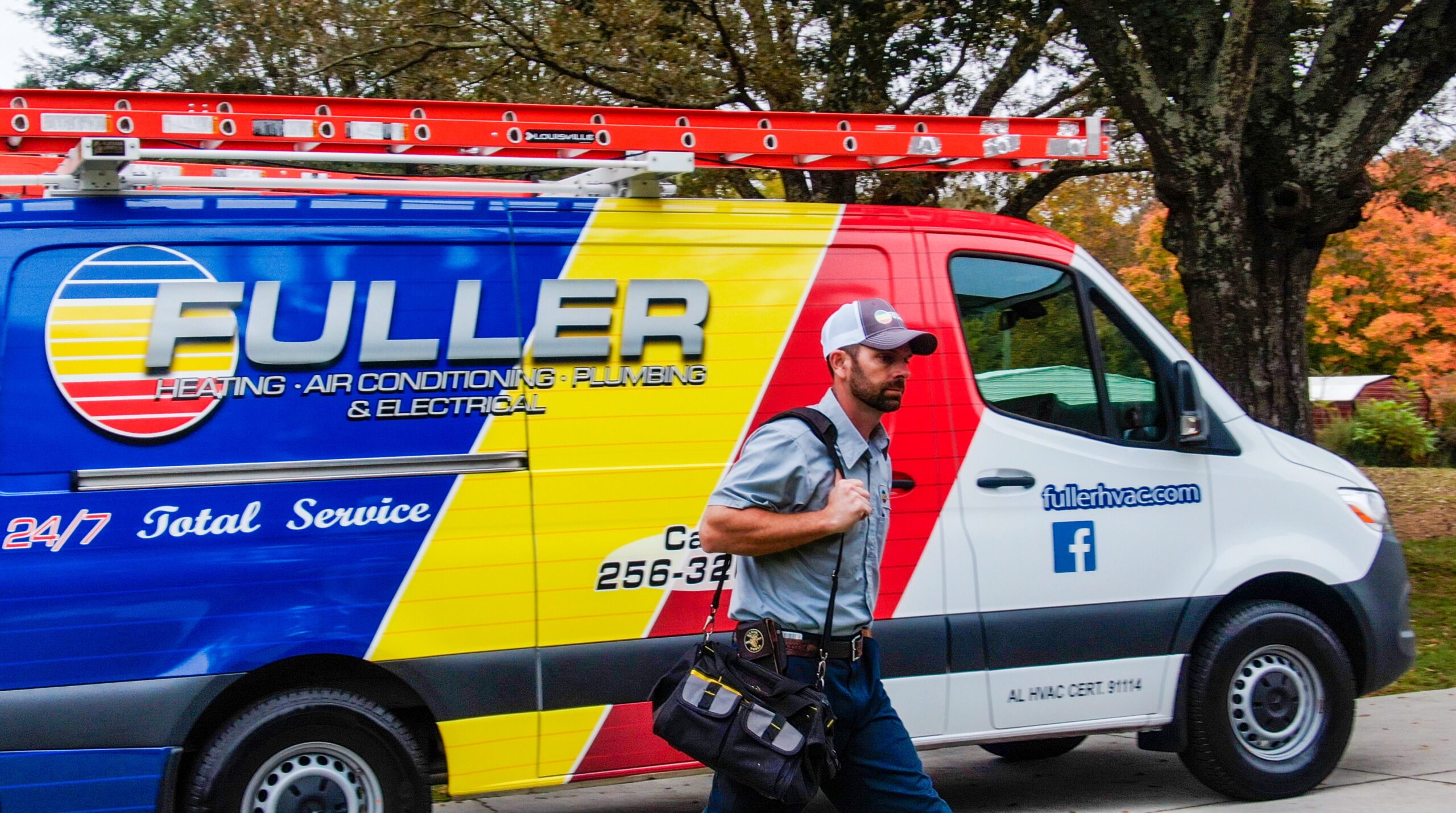 Fuller HVAC technician standing ready beside company service van