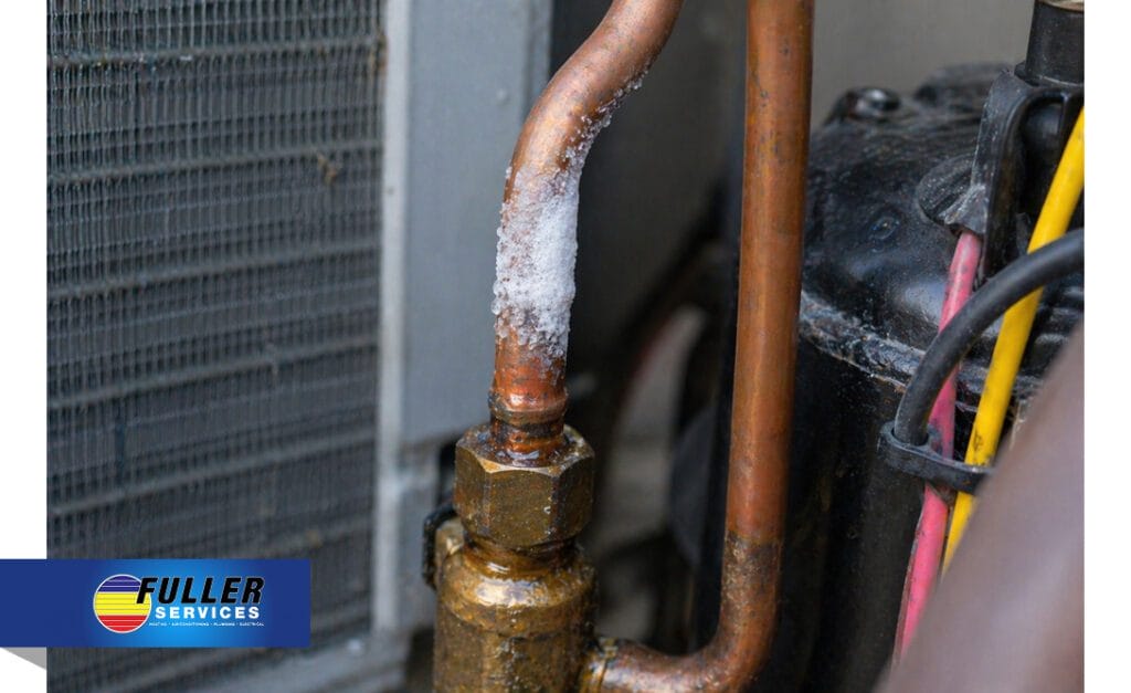Close-up of a copper refrigerant line with visible ice buildup inside an HVAC unit.