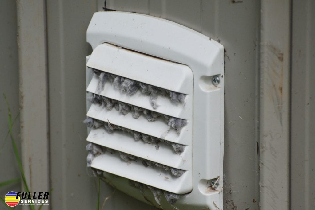 Exterior dryer vent clogged with heavy lint buildup blocking airflow.