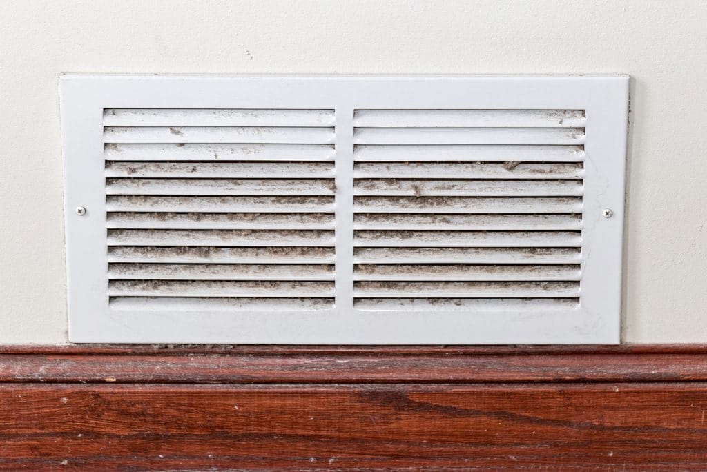 Dirty HVAC return air vent grille with visible dust and debris buildup.