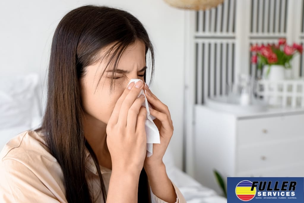 Woman sneezing indoors due to possible allergies or poor indoor air quality.
